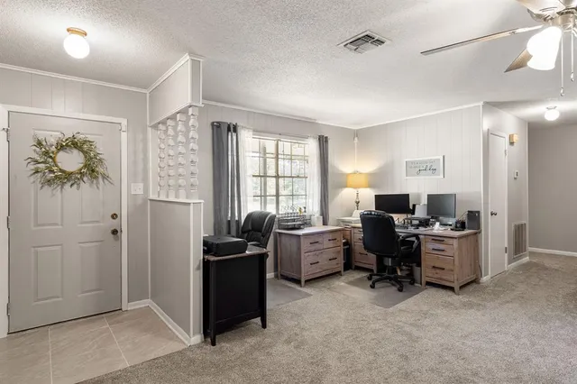 a view of a livingroom with workspace and a window