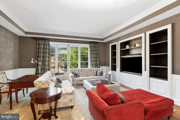 a living room with furniture a flat screen tv and large window