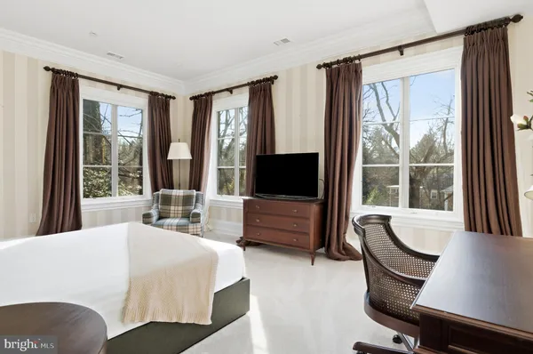 a bedroom with furniture and large windows