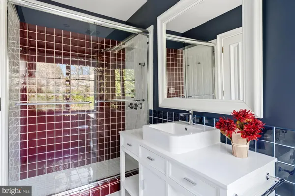 a bathroom with a sink mirror and shower