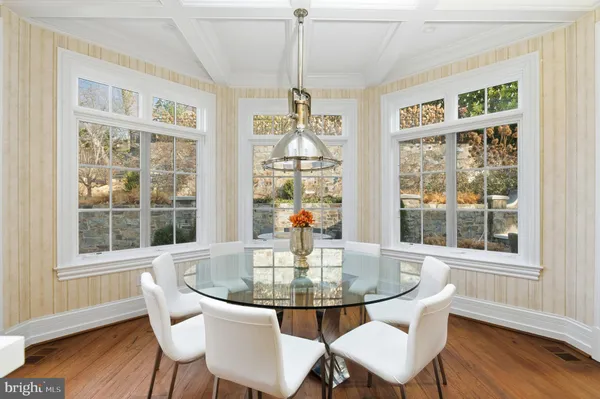 a dining room with furniture a chandelier and wooden floor