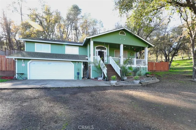 a view of a house with a yard and large tree