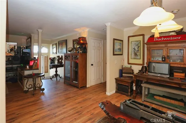 a living room with furniture and a dining table with wooden floor