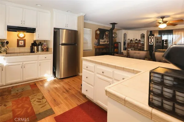 a kitchen with stainless steel appliances kitchen island a refrigerator sink and cabinets