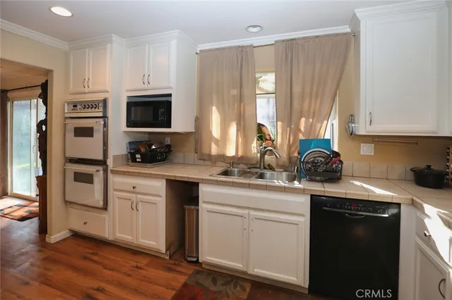 a kitchen with white cabinets and appliances