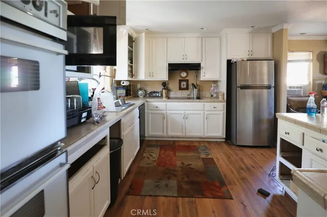 a kitchen with white cabinets and stainless steel appliances