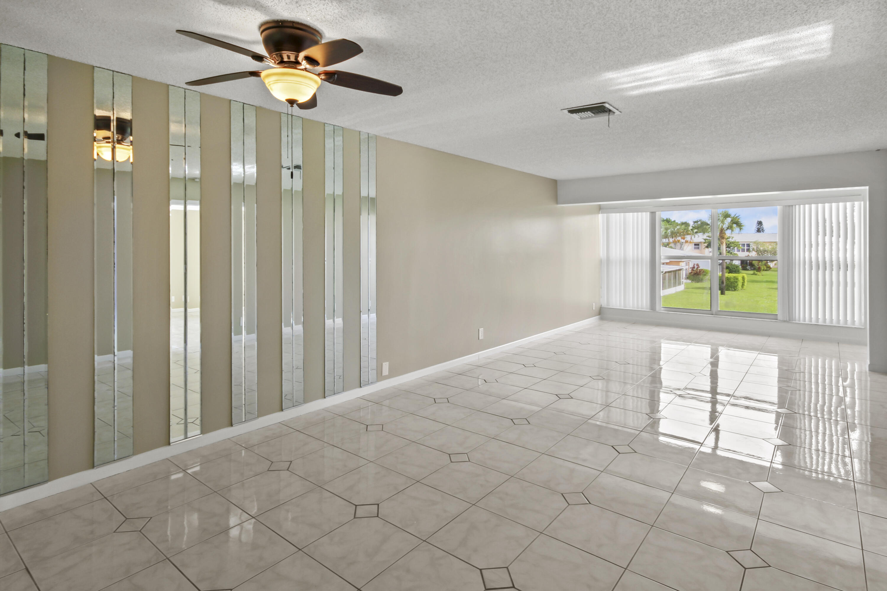 1421 Northwest 20th Avenue, Unit 204 Delray Beach, FL 33445 - Photo 11 of 22 a view of a hallway with a chandelier fan and windows