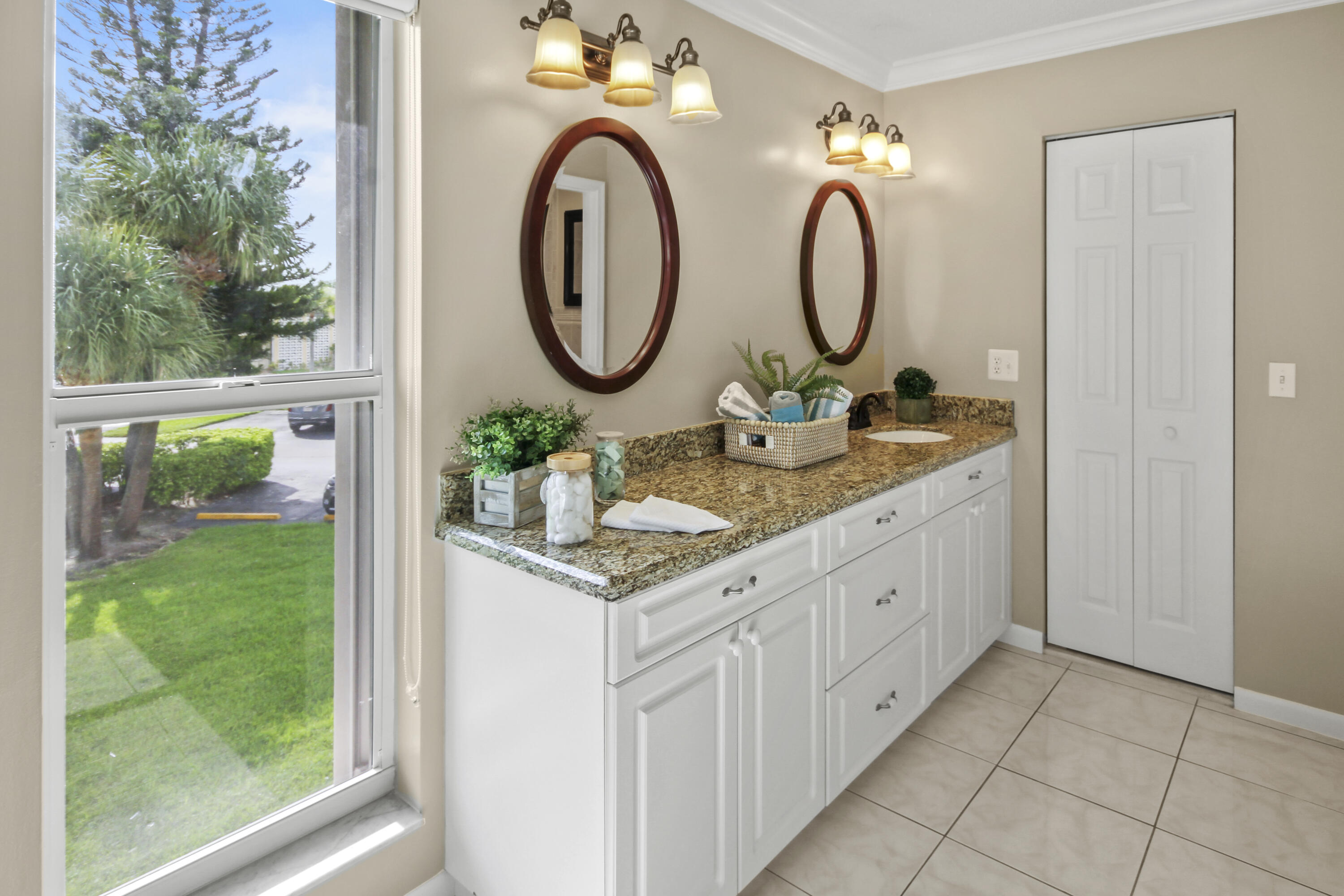 1421 Northwest 20th Avenue, Unit 204 Delray Beach, FL 33445 - Photo 18 of 22 a bathroom with a granite countertop sink and a mirror