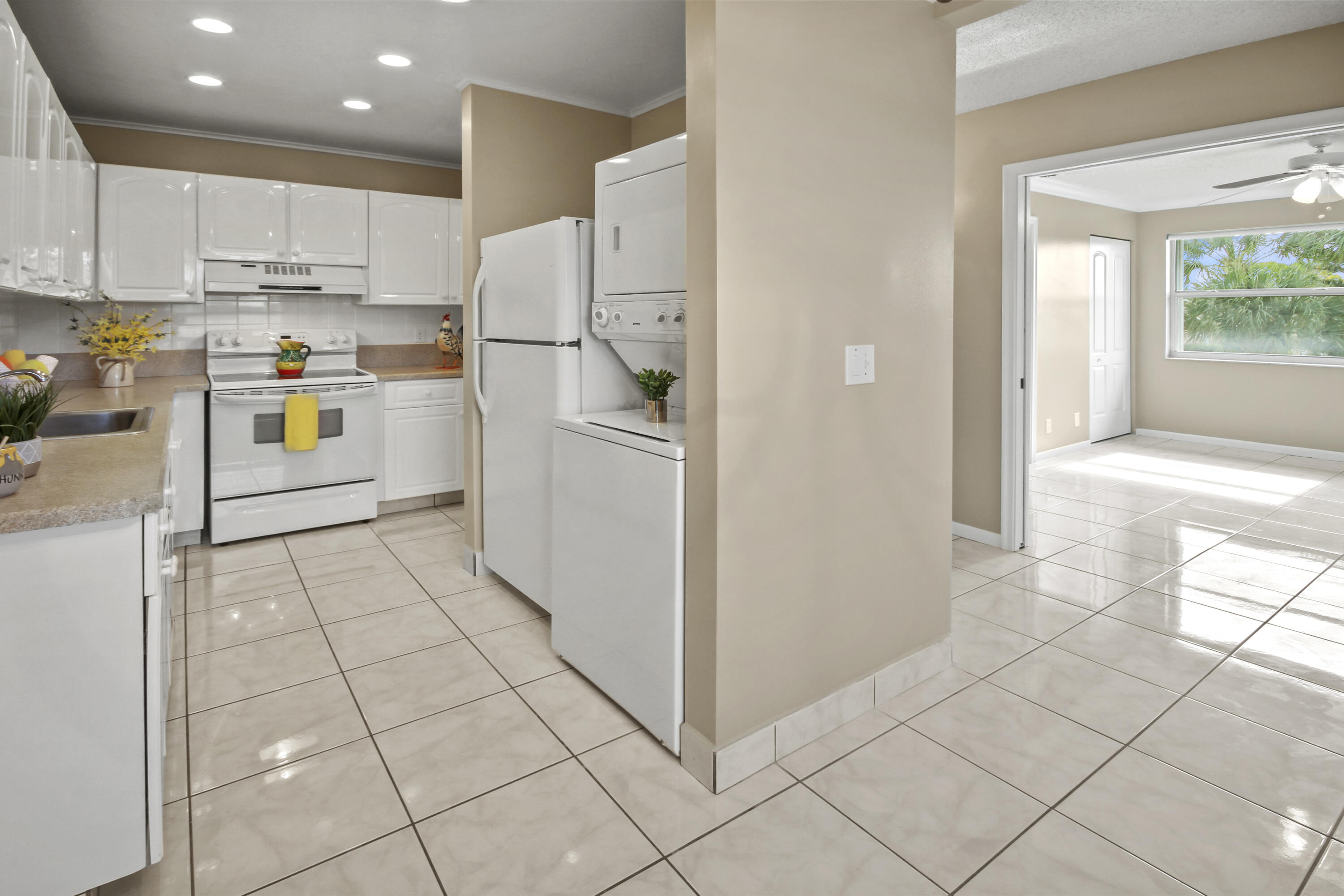 1421 Northwest 20th Avenue, Unit 204 Delray Beach, FL 33445 - Photo 2 of 22 a kitchen with white cabinets and white appliances