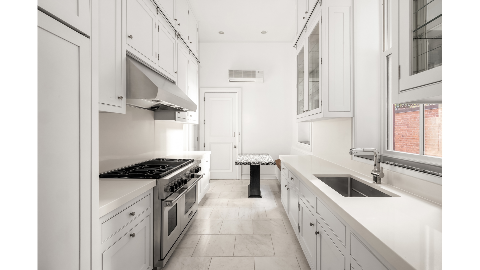 18 East 62nd Street Manhattan, NY 10065 - Photo 9 of 19 a kitchen with stainless steel appliances a sink a stove a refrigerator a window and cabinets