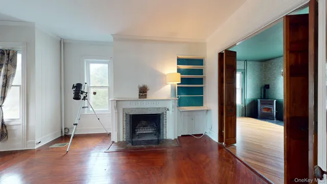 a view of a livingroom with wooden floor and a fireplace