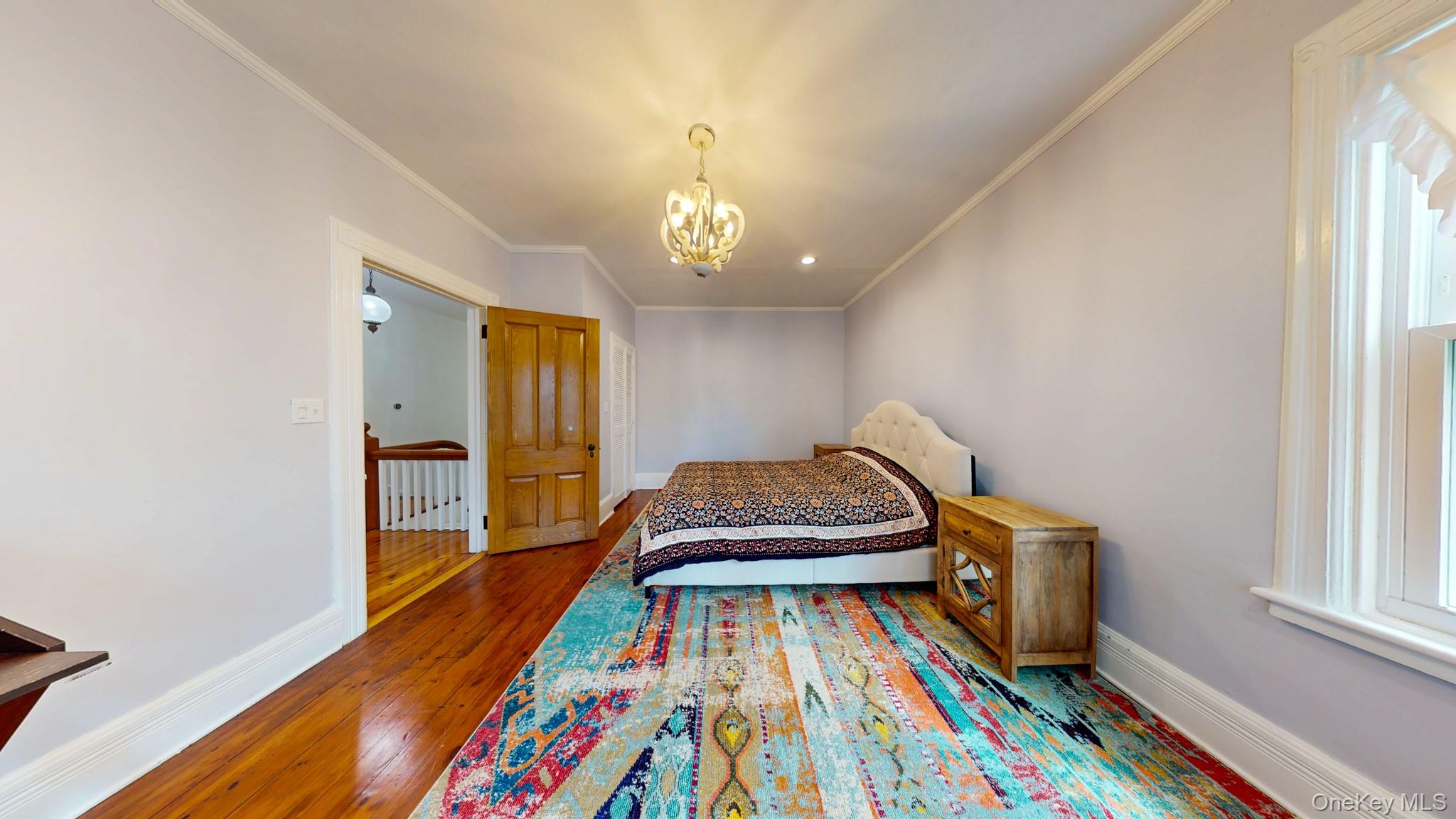 12 Perry Creek Road Washingtonville, NY 10992 - Photo 23 of 50 a bedroom with a bed and a chandelier