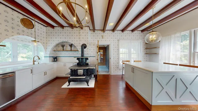 a living room with stainless steel appliances kitchen island granite countertop furniture and a wooden floor