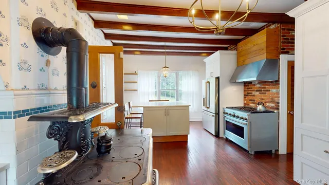 a kitchen with stainless steel appliances granite countertop a stove and a wooden floors