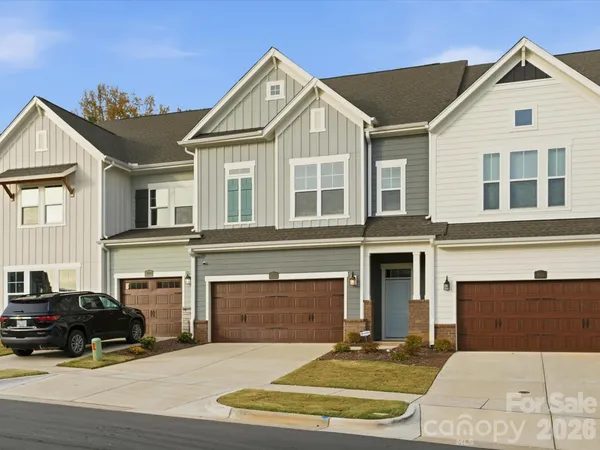 a front view of a house with yard and parking