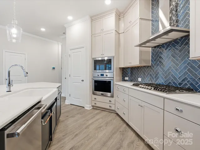 a kitchen with granite countertop a sink stainless steel appliances and cabinets