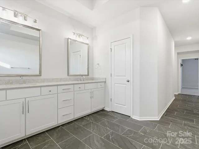 a spacious bathroom with 2 sink and a mirror