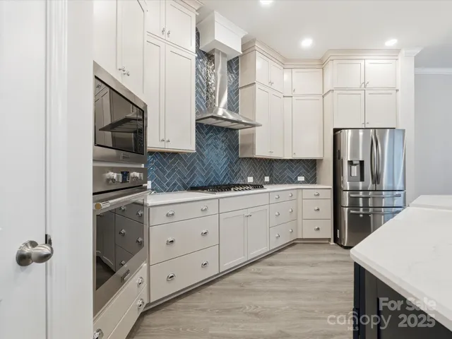 a kitchen with stainless steel appliances granite countertop a refrigerator and a stove top oven