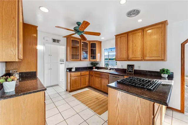 a kitchen with stainless steel appliances granite countertop a stove a sink a refrigerator a counter space and cabinets