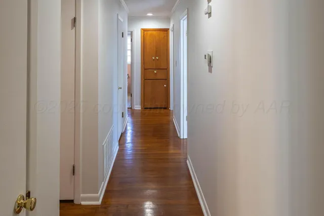 a view of a hallway with wooden floor
