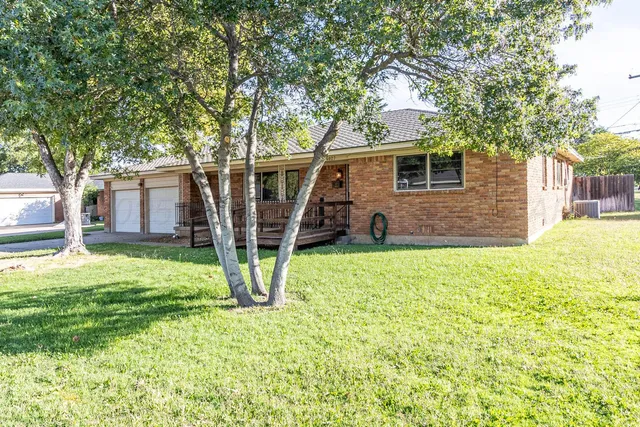 a view of a house with backyard and a tree