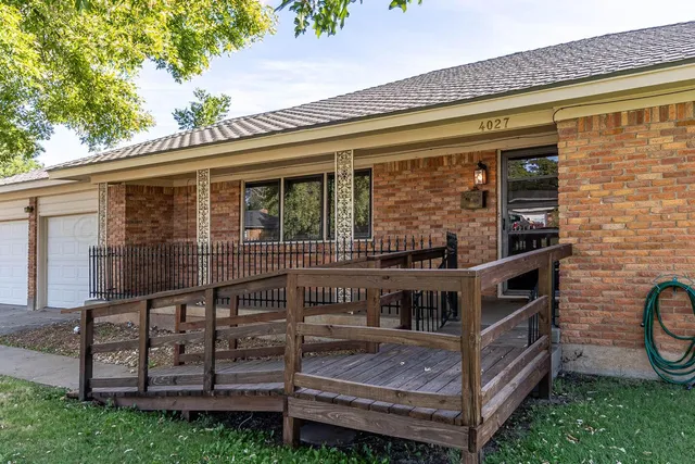 a view of a house with a small yard and wooden fence