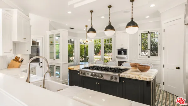 a kitchen with stainless steel appliances kitchen island granite countertop a stove and a sink