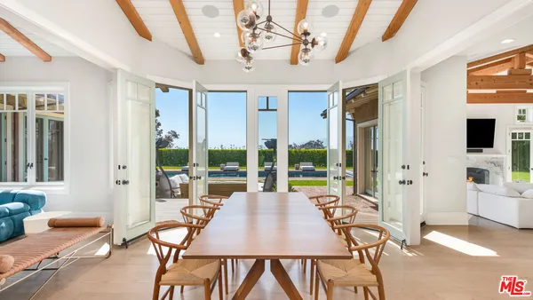 a dining room with furniture a chandelier and wooden floor