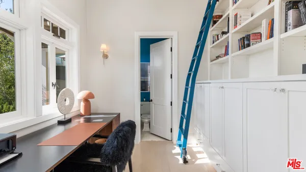a view of a workspace with furniture and a window