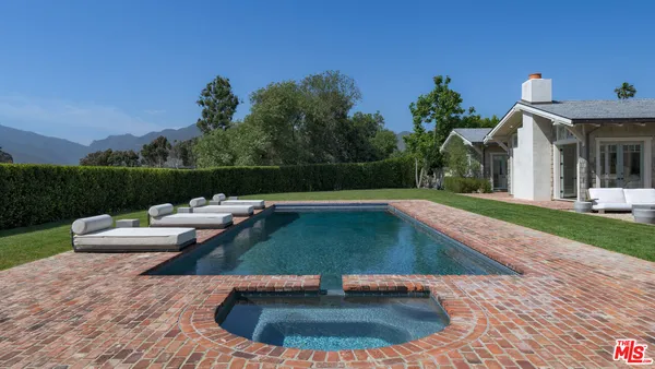a view of house with swimming pool and yard