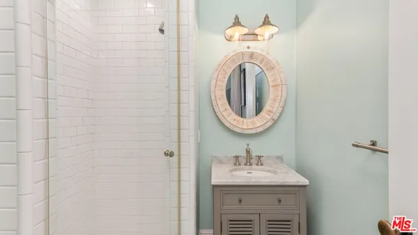 a bathroom with a granite countertop sink and a mirror