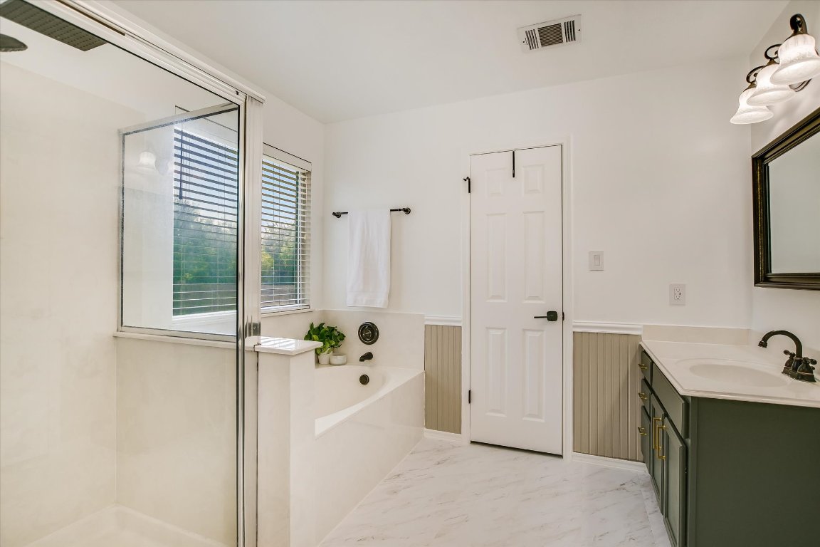 1302 Redbud Lane Leander, TX 78641 - Photo 17 of 28 a bathroom with a tub sink and mirror