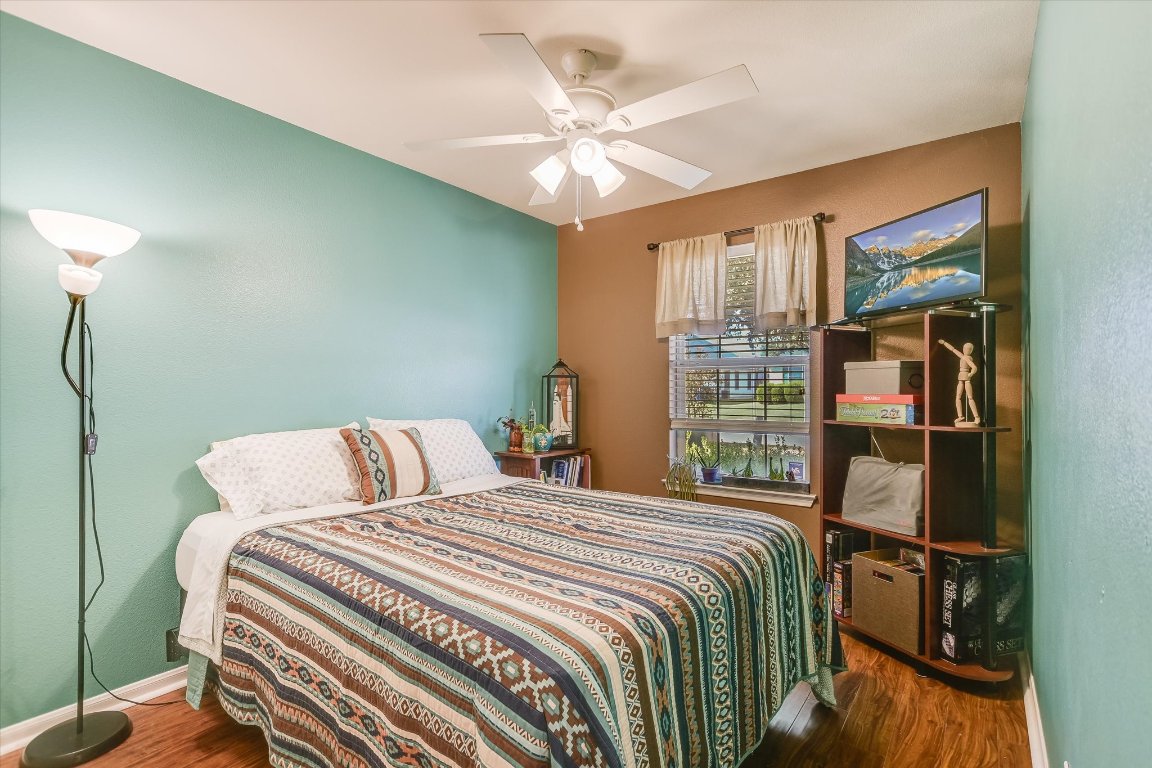 1302 Redbud Lane Leander, TX 78641 - Photo 19 of 28 a bedroom with a bed and a chandelier