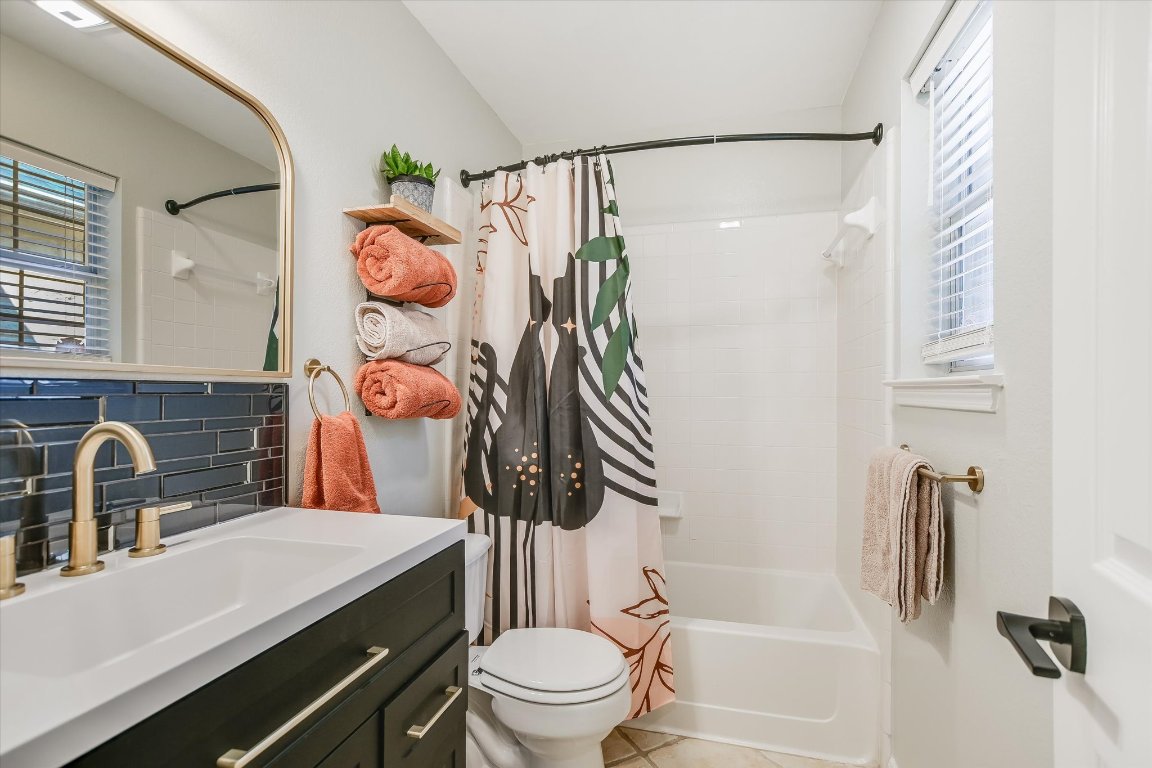 1302 Redbud Lane Leander, TX 78641 - Photo 20 of 28 a bathroom with a sink a toilet and a shower curtain