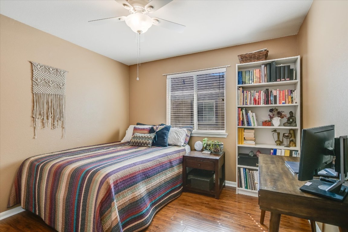 1302 Redbud Lane Leander, TX 78641 - Photo 21 of 28 a bedroom with a bed bookshelf and a window