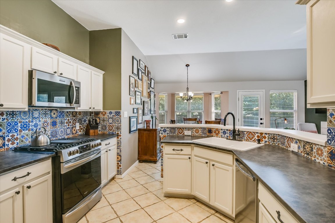 1302 Redbud Lane Leander, TX 78641 - Photo 7 of 28 a kitchen with a sink stove and microwave