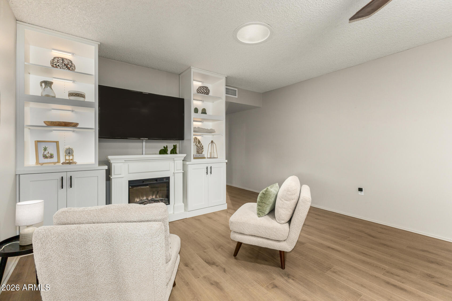 9933 West Mountain View Road Sun City, AZ 85351 - Photo 10 of 24 a living room with furniture a fireplace and a flat screen tv