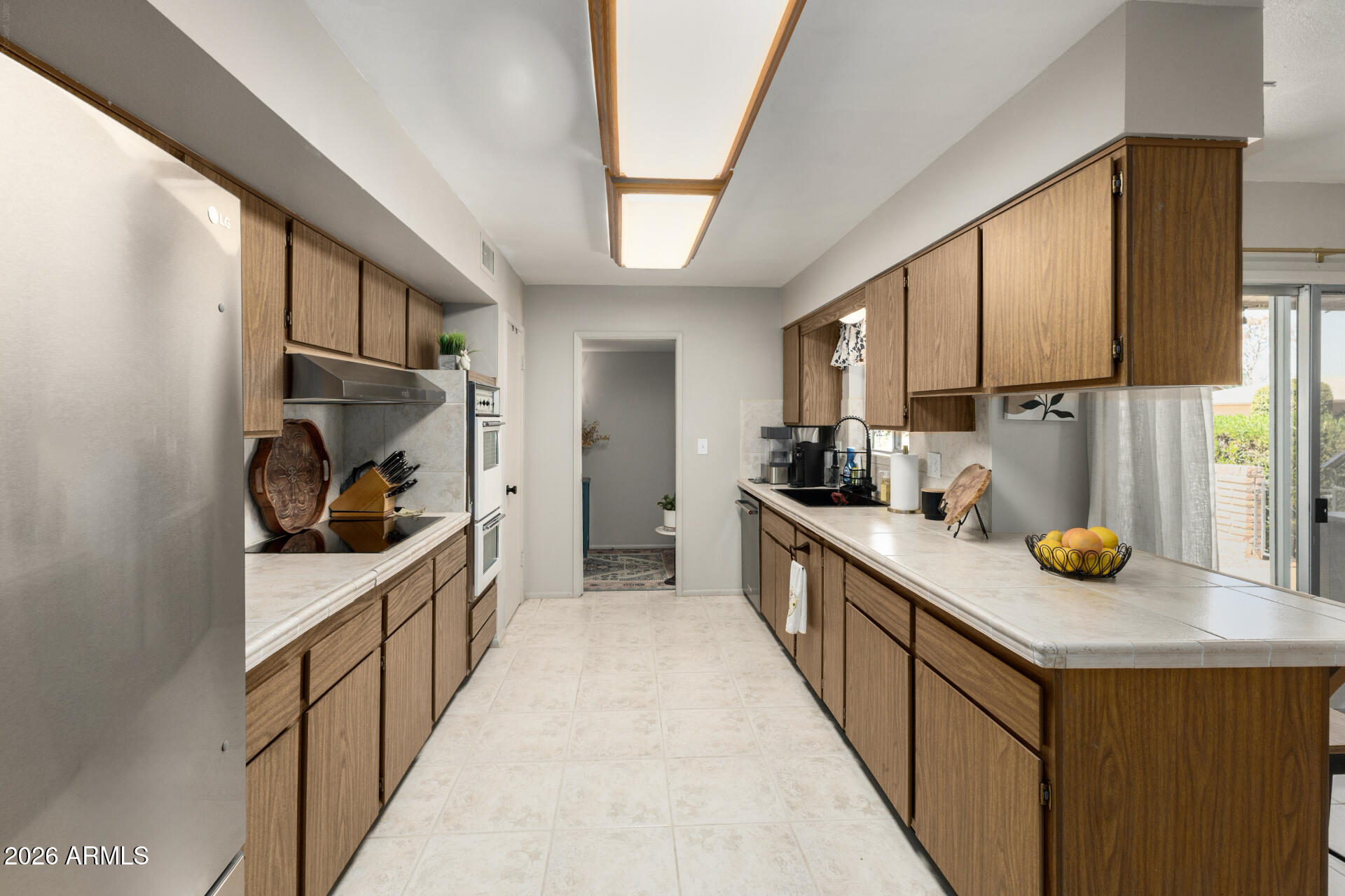 9933 West Mountain View Road Sun City, AZ 85351 - Photo 15 of 24 a kitchen with stainless steel appliances a sink stove and cabinets