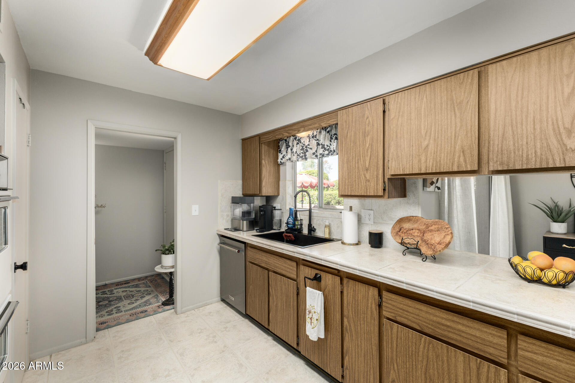 9933 West Mountain View Road Sun City, AZ 85351 - Photo 16 of 24 a kitchen with sink a window and cabinets