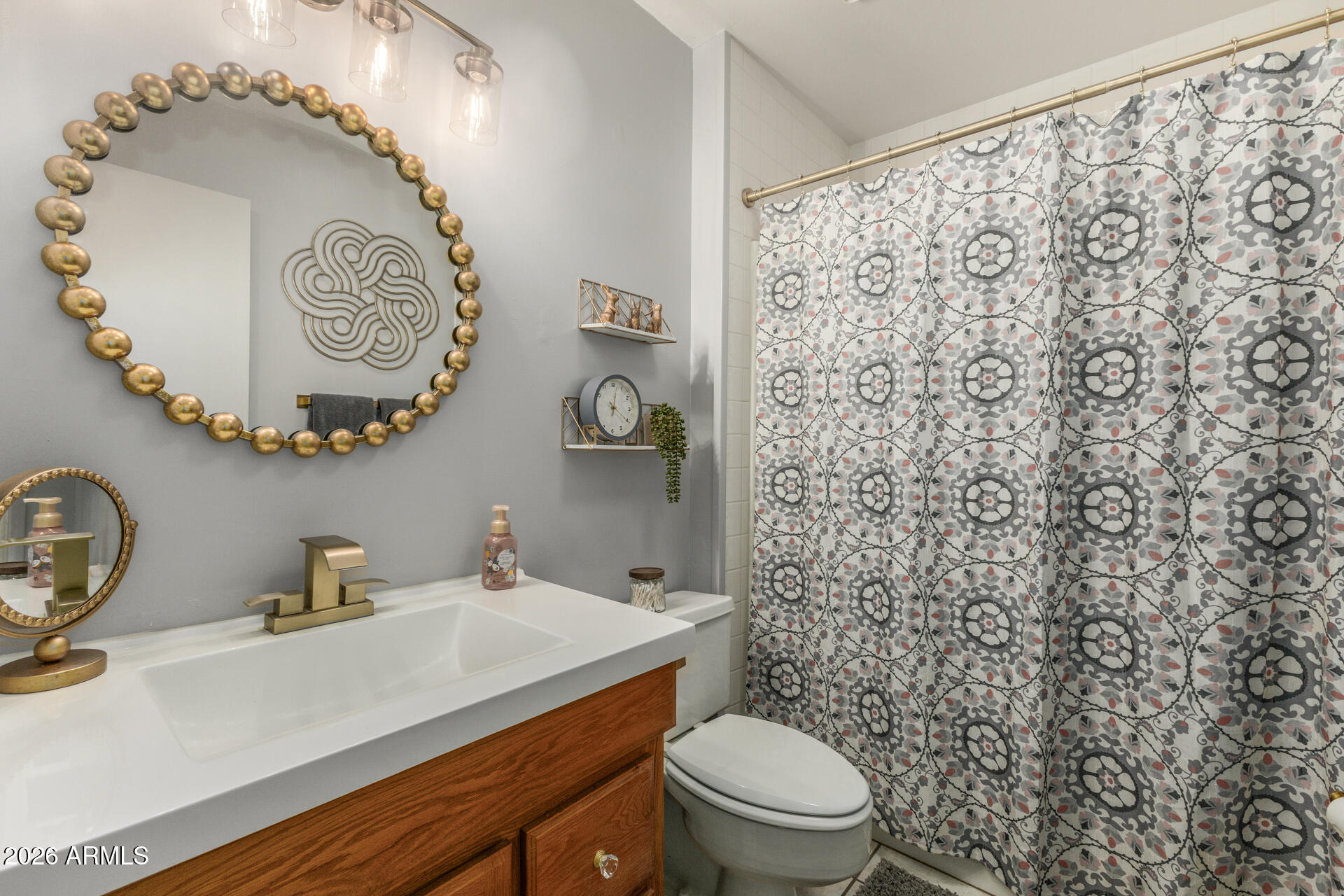 9933 West Mountain View Road Sun City, AZ 85351 - Photo 21 of 24 a bathroom with a sink a toilet and a mirror