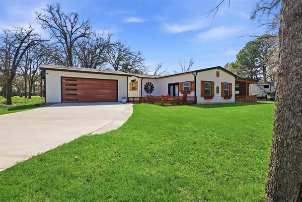 front view of a house with a yard and trees