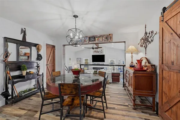 a view of a dining room with furniture a chandelier and wooden floor