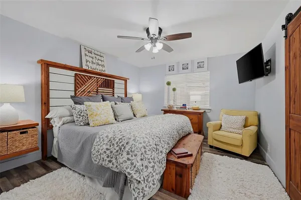 a bedroom with a bed a couch and a flat screen tv