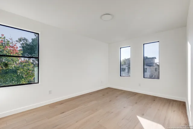 an empty room with wooden floor and window