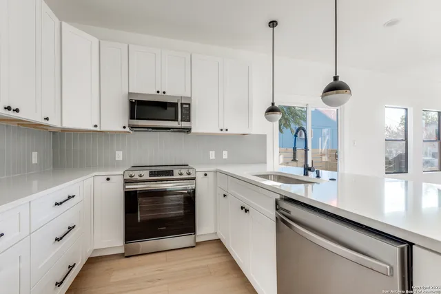a kitchen with appliances cabinets and a sink