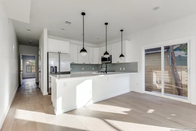 a large kitchen with kitchen island a sink a counter space stainless steel appliances and cabinets