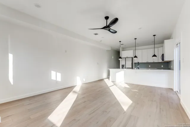 a view of empty room with wooden floor and window