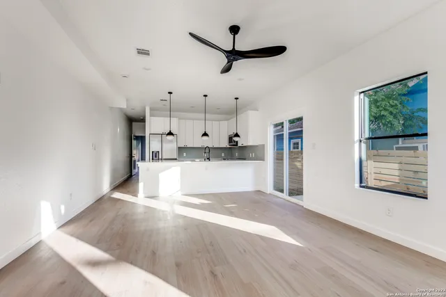 a view of a kitchen with wooden floor windows and a ceiling fan