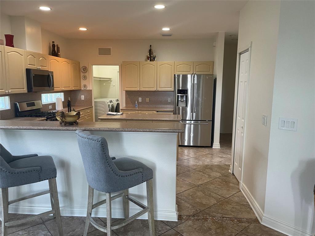 10690 OldHammock Way Wellington, FL 33414 - Photo 3 of 9 a kitchen with refrigerator and chairs