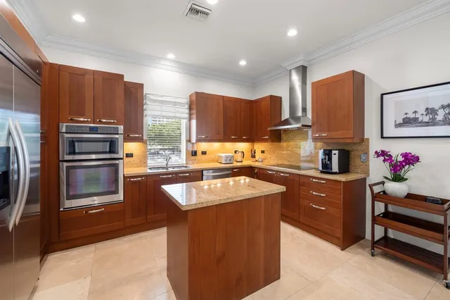 a kitchen with stainless steel appliances granite countertop a refrigerator a stove and a sink
